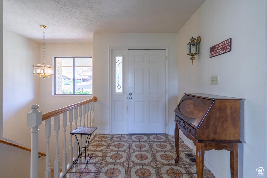 Entrance foyer with a chandelier and a textured ceiling