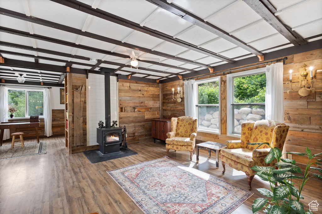 Living area featuring wood walls, a wood stove, and wood finished floors