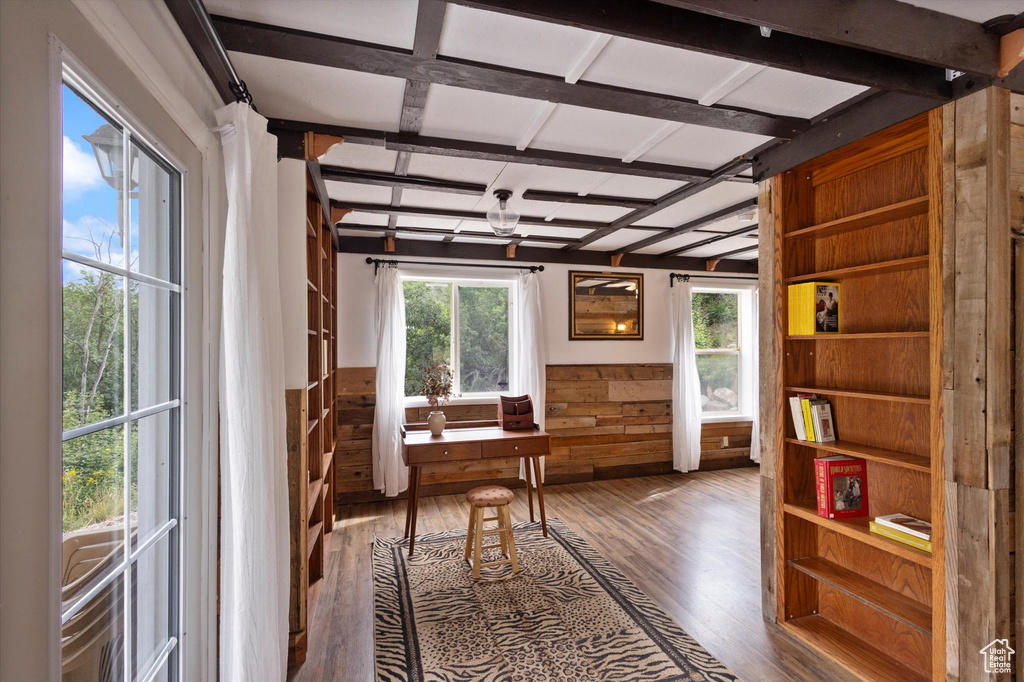 Home office with wood finished floors, wooden walls, and a wainscoted wall