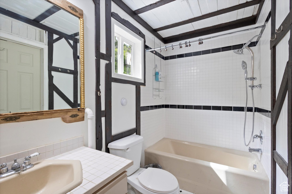 Bathroom with vanity, bathing tub / shower combination, and tasteful backsplash