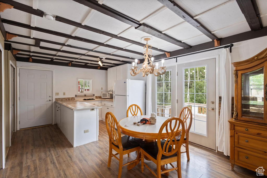 Dining space with wood finished floors and a chandelier