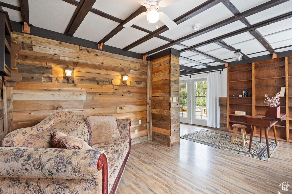 Living area with wood walls, wood finished floors, and a ceiling fan