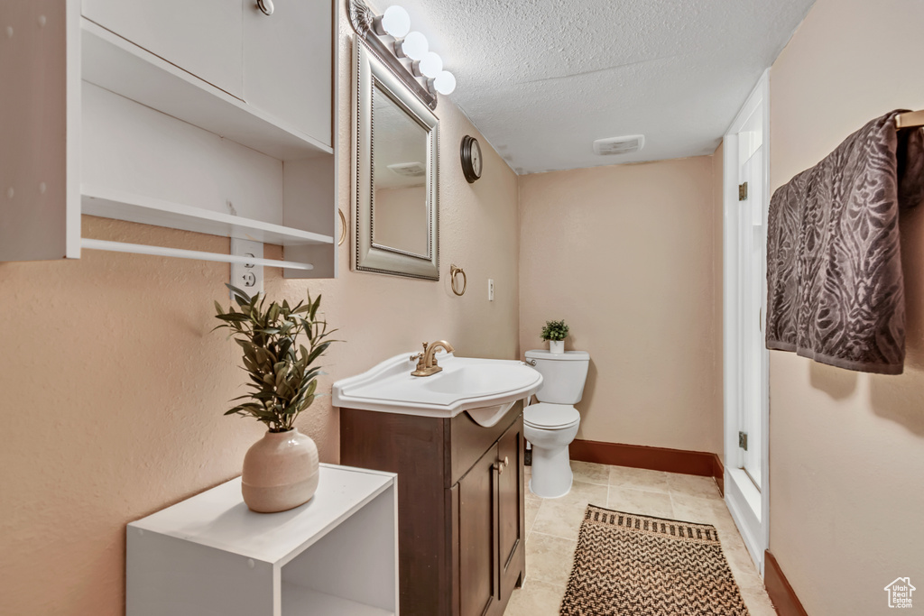 Bathroom featuring vanity, a textured ceiling, and tile patterned flooring