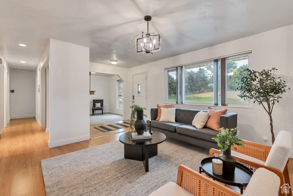 Living room featuring light wood-style floors, a chandelier, and recessed lighting