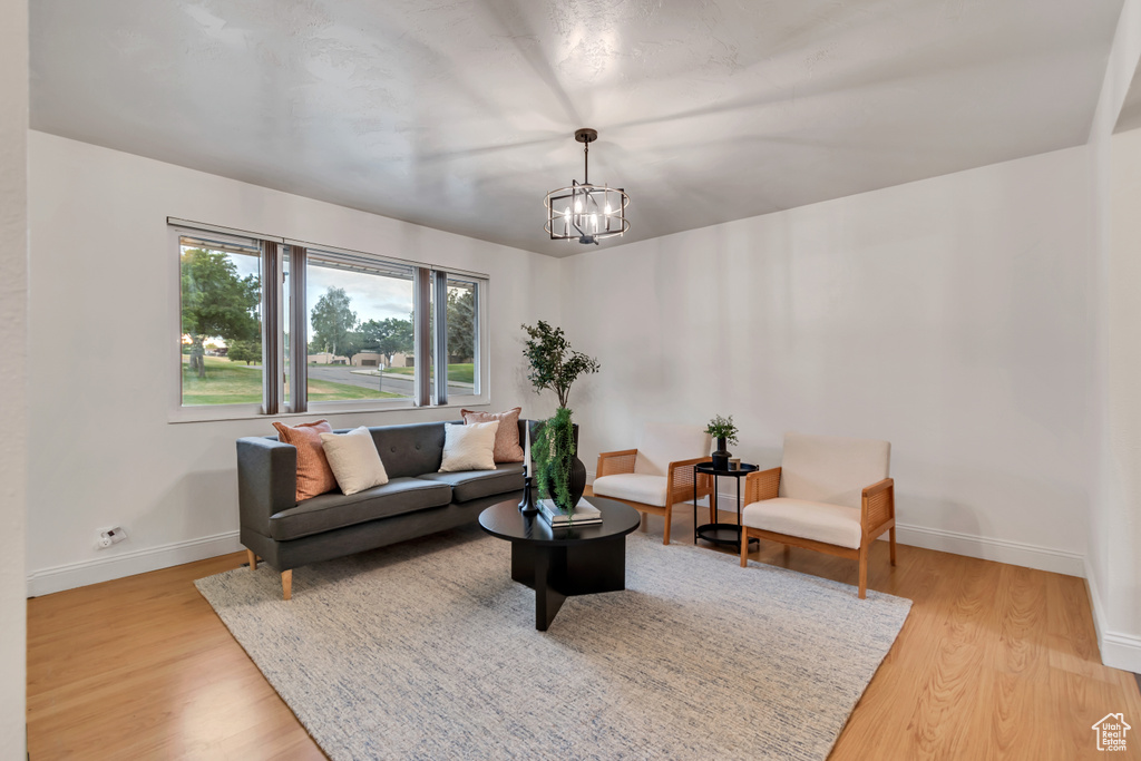 Living room with light wood-type flooring and a chandelier