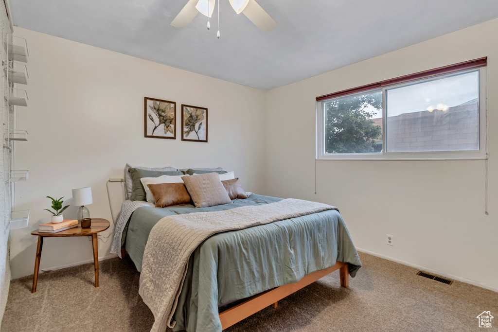 Carpeted bedroom featuring baseboards and a ceiling fan