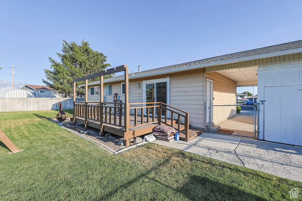 Back of house with a deck and a gate