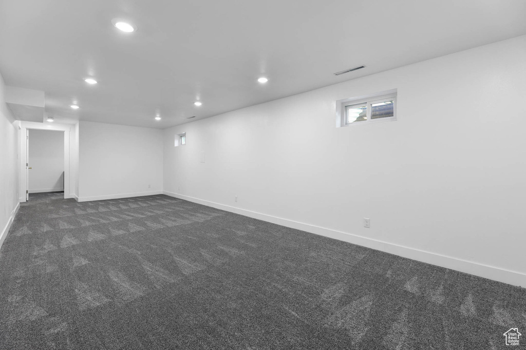 Below grade area featuring recessed lighting and dark colored carpet