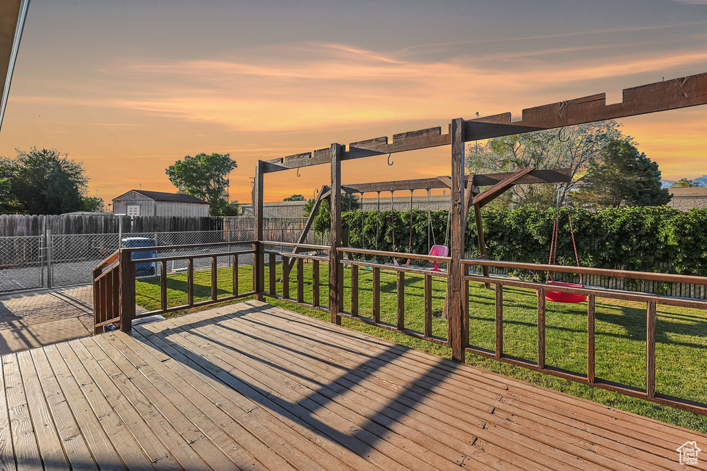 Deck at dusk featuring a fenced backyard