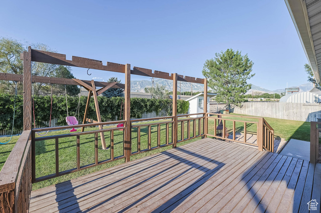 Wooden terrace with a fenced backyard, a storage unit, and a mountain view