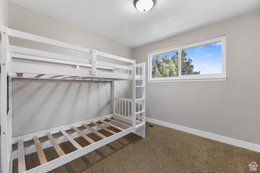 Unfurnished bedroom with baseboards and carpet floors