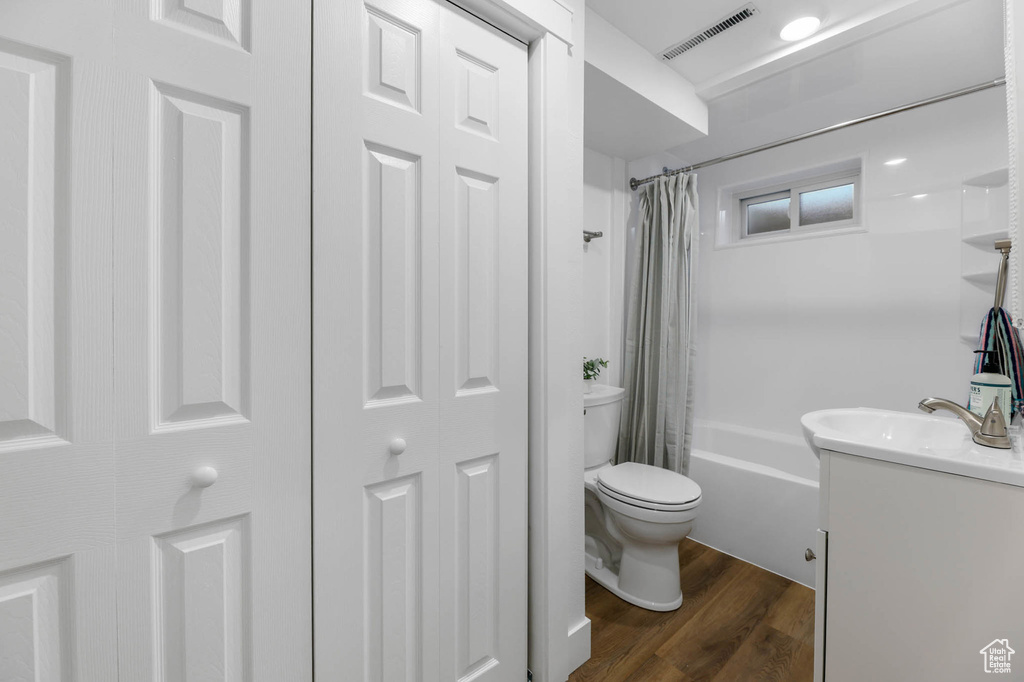 Full bathroom featuring vanity, a closet, shower / tub combo, and wood finished floors