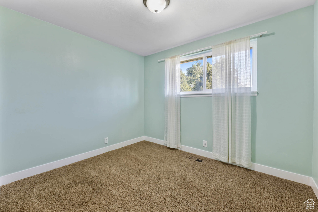 Carpeted spare room with baseboards