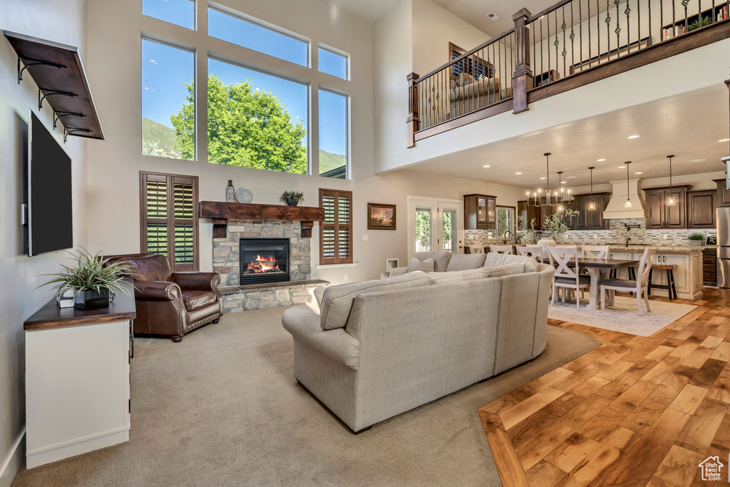 Living room with a fireplace, a high ceiling, and light wood finished floors