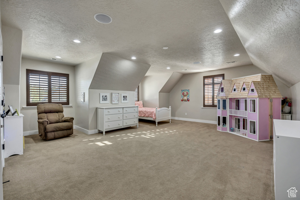 Bedroom with a textured ceiling, vaulted ceiling, carpet, and recessed lighting