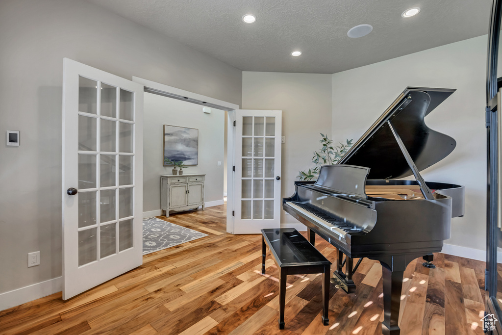 Living area featuring french doors, wood finished floors, recessed lighting, and a textured ceiling