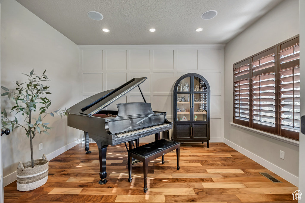 Living area featuring light wood-type flooring, recessed lighting, and a textured ceiling
