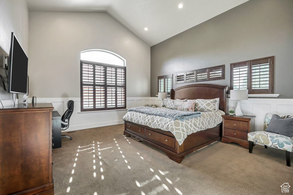 Bedroom with high vaulted ceiling, a wainscoted wall, a desk, carpet floors, and recessed lighting