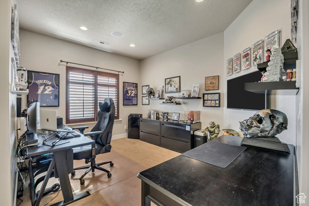 Office area with a textured ceiling, recessed lighting, and light colored carpet