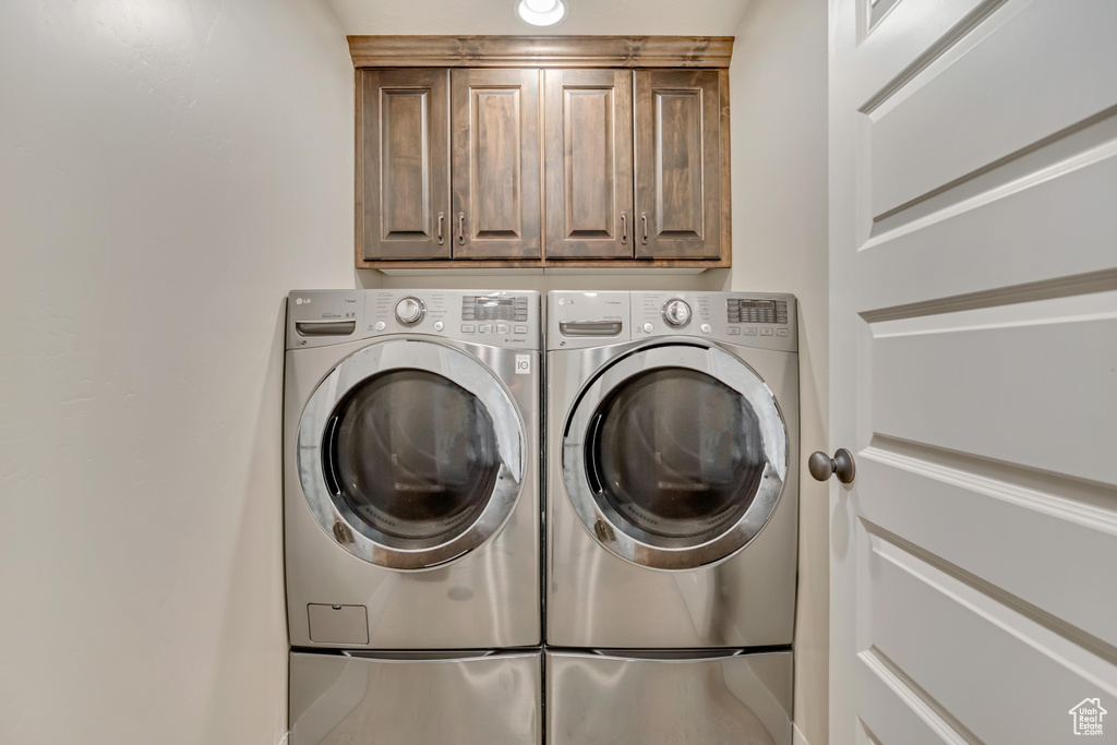 Laundry area featuring cabinet space and separate washer and dryer