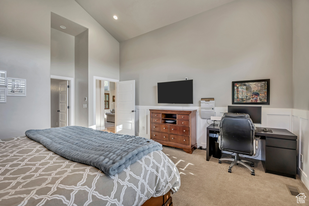 Bedroom with high vaulted ceiling, carpet, a desk, and wainscoting