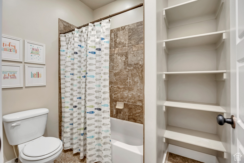Full bath with shower / bath combo with shower curtain and toilet