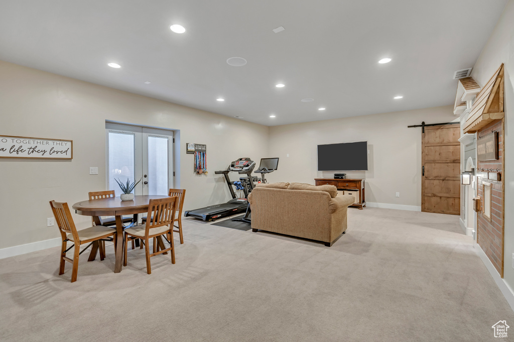 Dining room featuring a barn door, light carpet, and recessed lighting