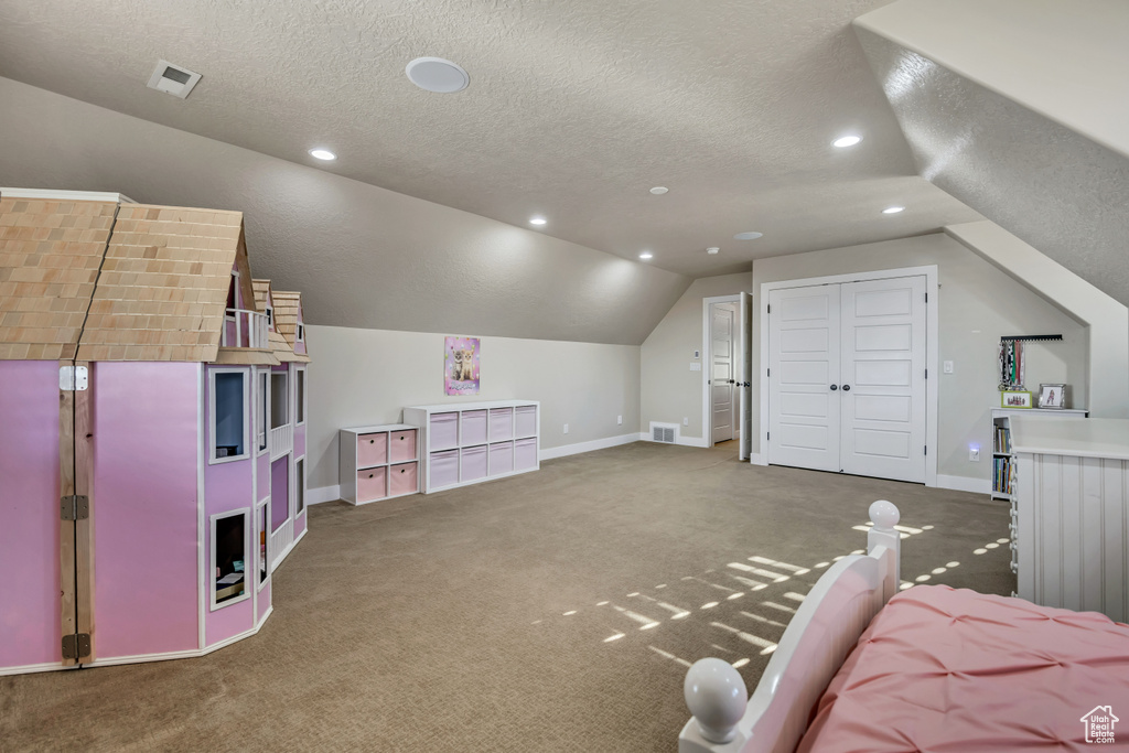 Bedroom featuring lofted ceiling, carpet flooring, a textured ceiling, a closet, and recessed lighting