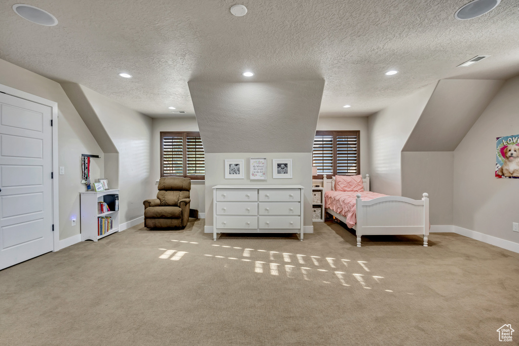 Bedroom with a textured ceiling, carpet floors, and recessed lighting