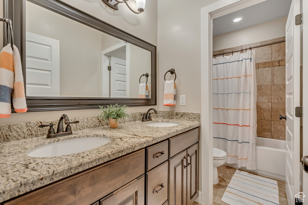 Full bathroom featuring double vanity, shower / tub combo with curtain, and recessed lighting