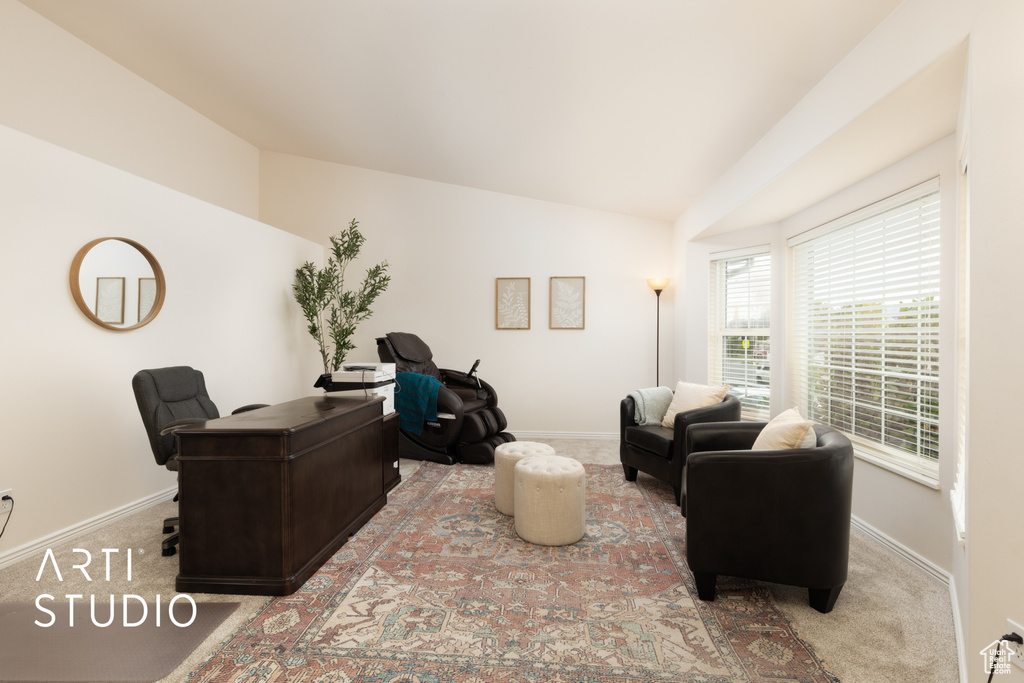Office area with vaulted ceiling and carpet flooring