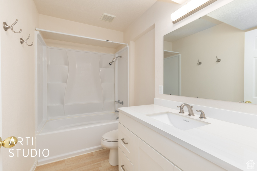Bathroom featuring vanity, wood finished floors, and  shower combination