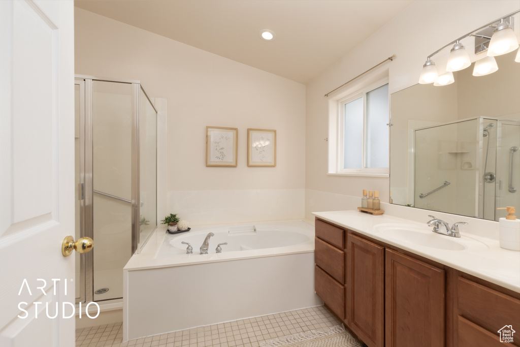 Bathroom featuring vanity, a stall shower, a garden tub, and tile patterned flooring