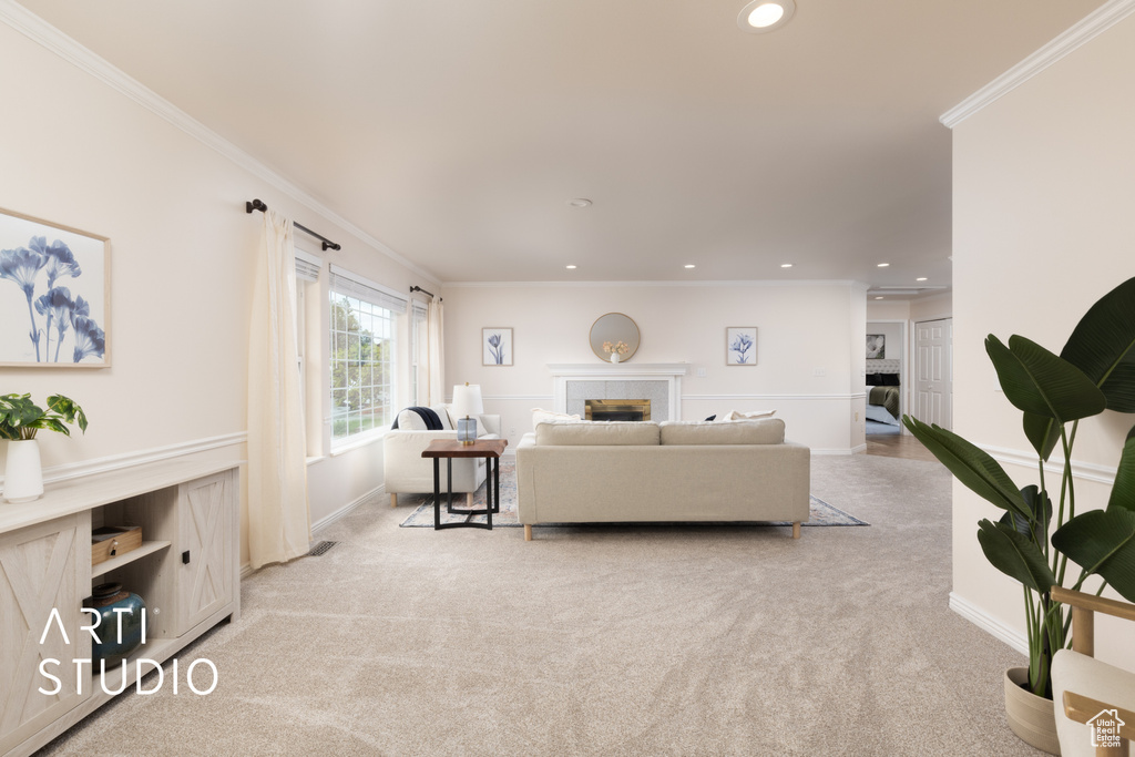 Living area featuring light carpet, a tiled fireplace, crown molding, and recessed lighting