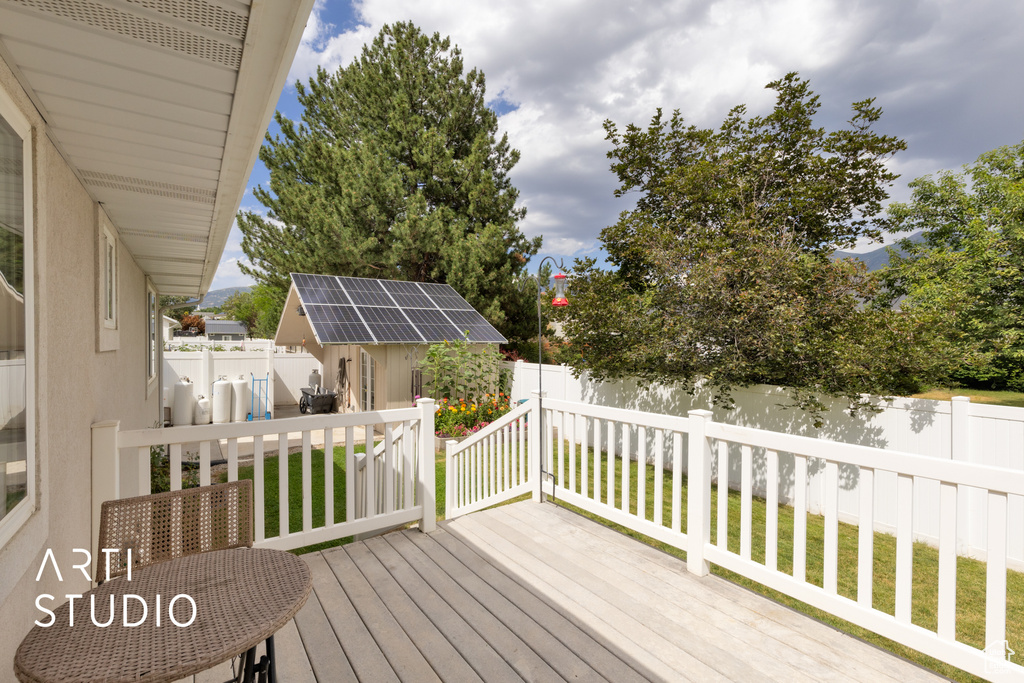 Wooden deck featuring a fenced backyard and an outbuilding