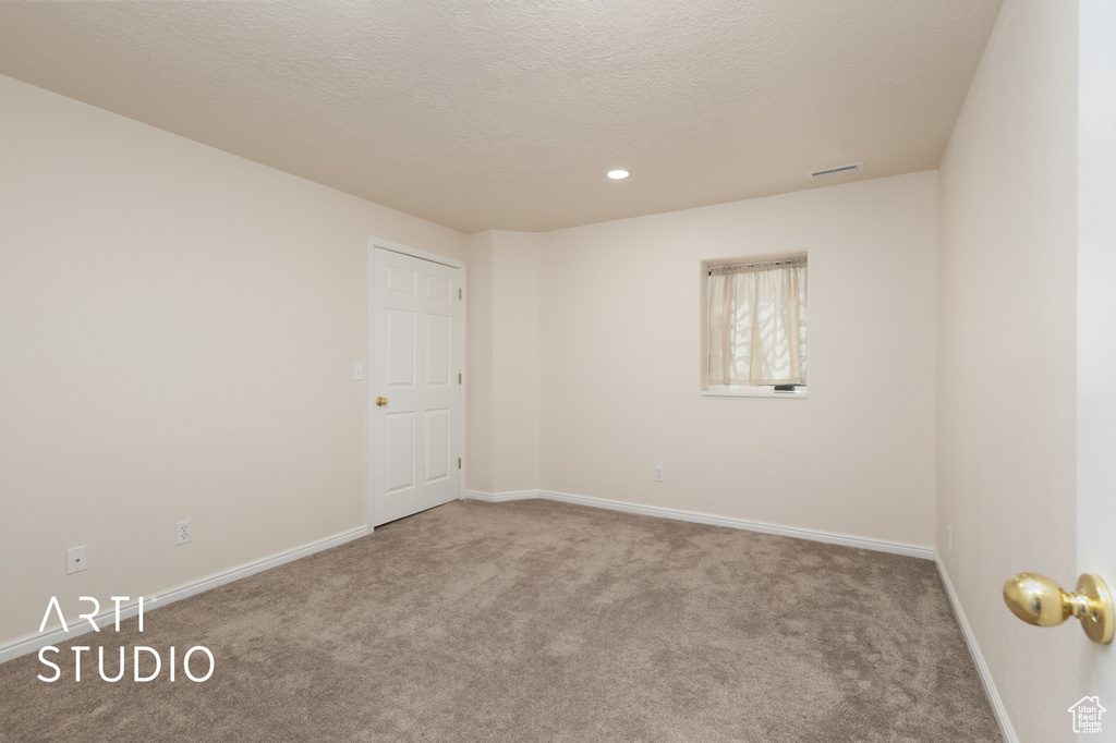 Unfurnished room with carpet floors, recessed lighting, and a textured ceiling