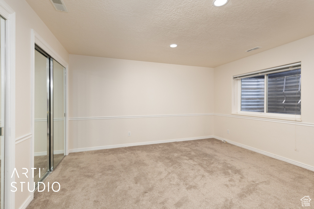 Unfurnished bedroom featuring carpet flooring, recessed lighting, a textured ceiling, and a closet