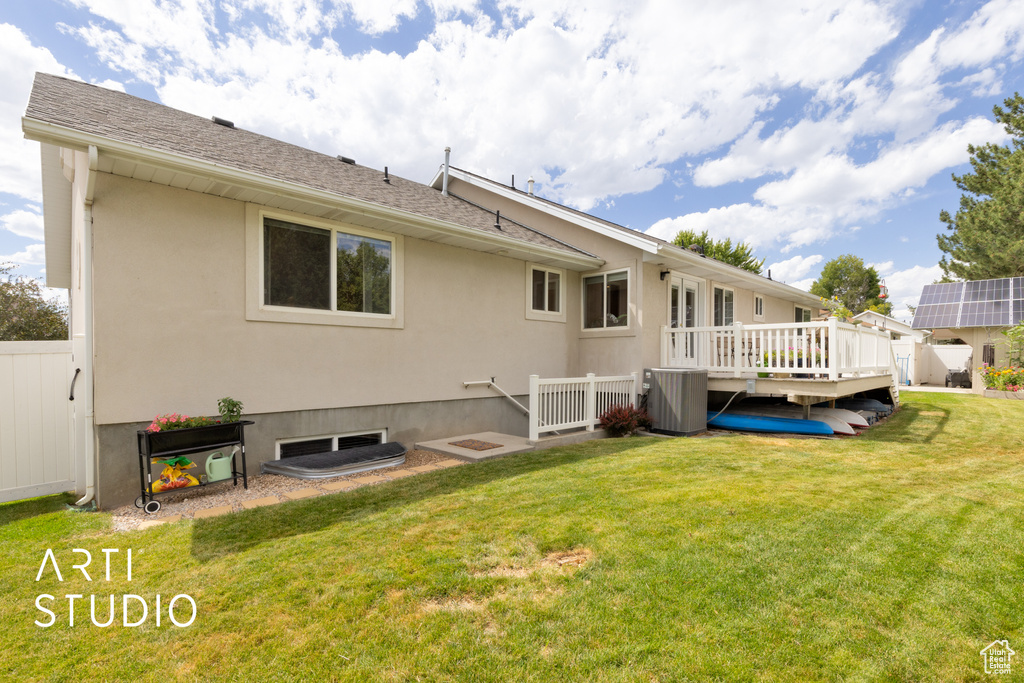 Back of property with a deck and stucco siding