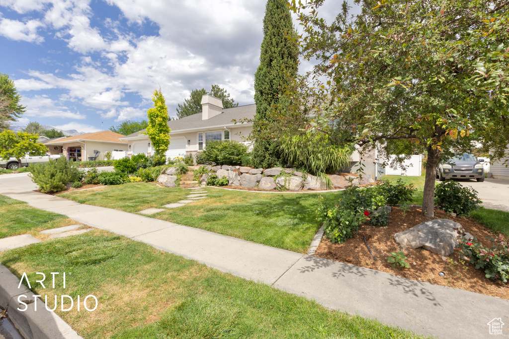 View of front of home featuring a front lawn and a garage