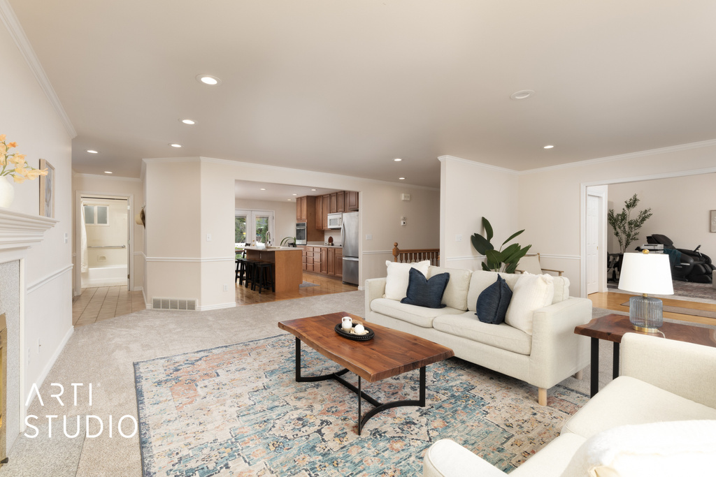 Living area with ornamental molding, recessed lighting, and light colored carpet