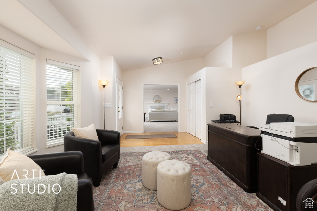 Office with vaulted ceiling and wood finished floors