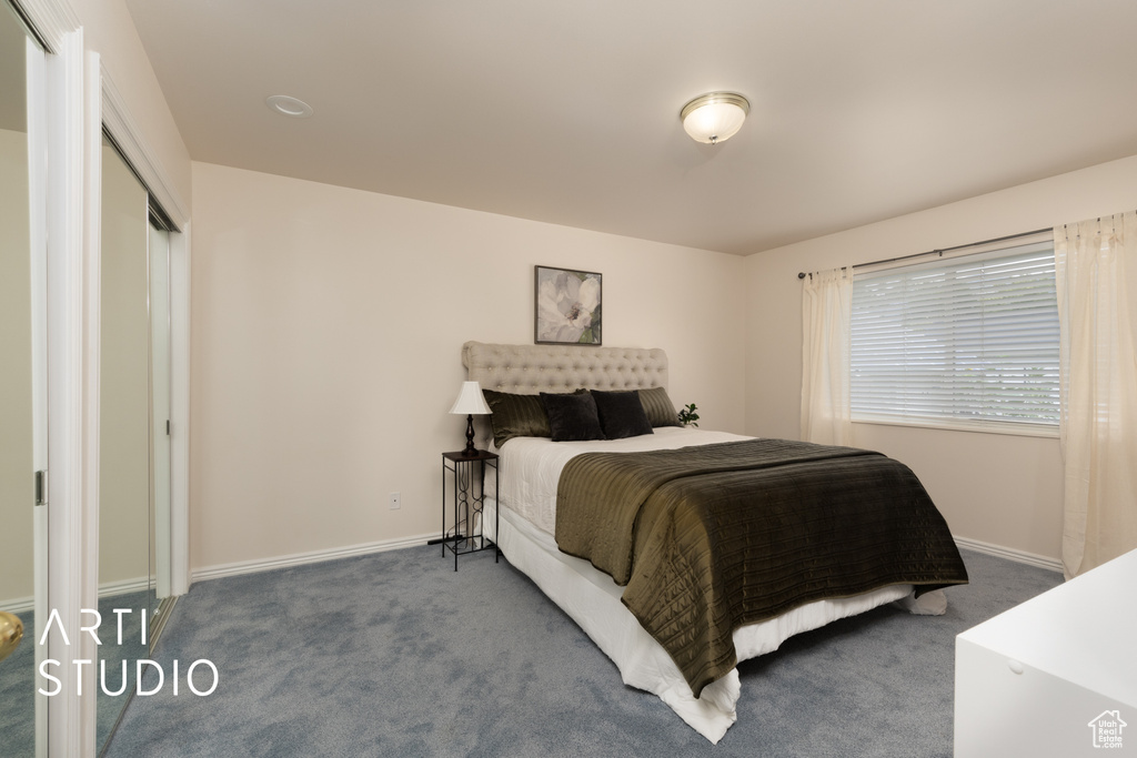 Carpeted bedroom featuring baseboards and a closet