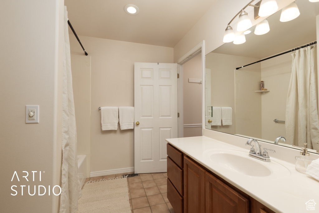 Full bath with vanity, tile patterned flooring, and shower / tub combo