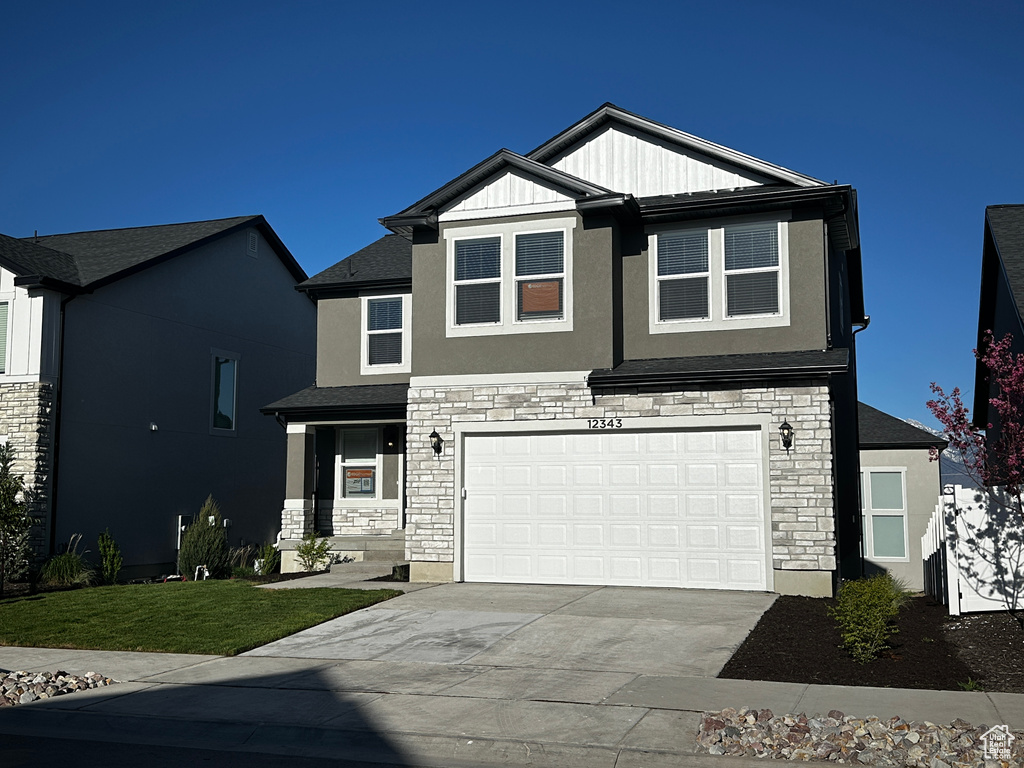 Craftsman inspired home with stone siding, driveway, an attached garage, stucco siding, and a front yard