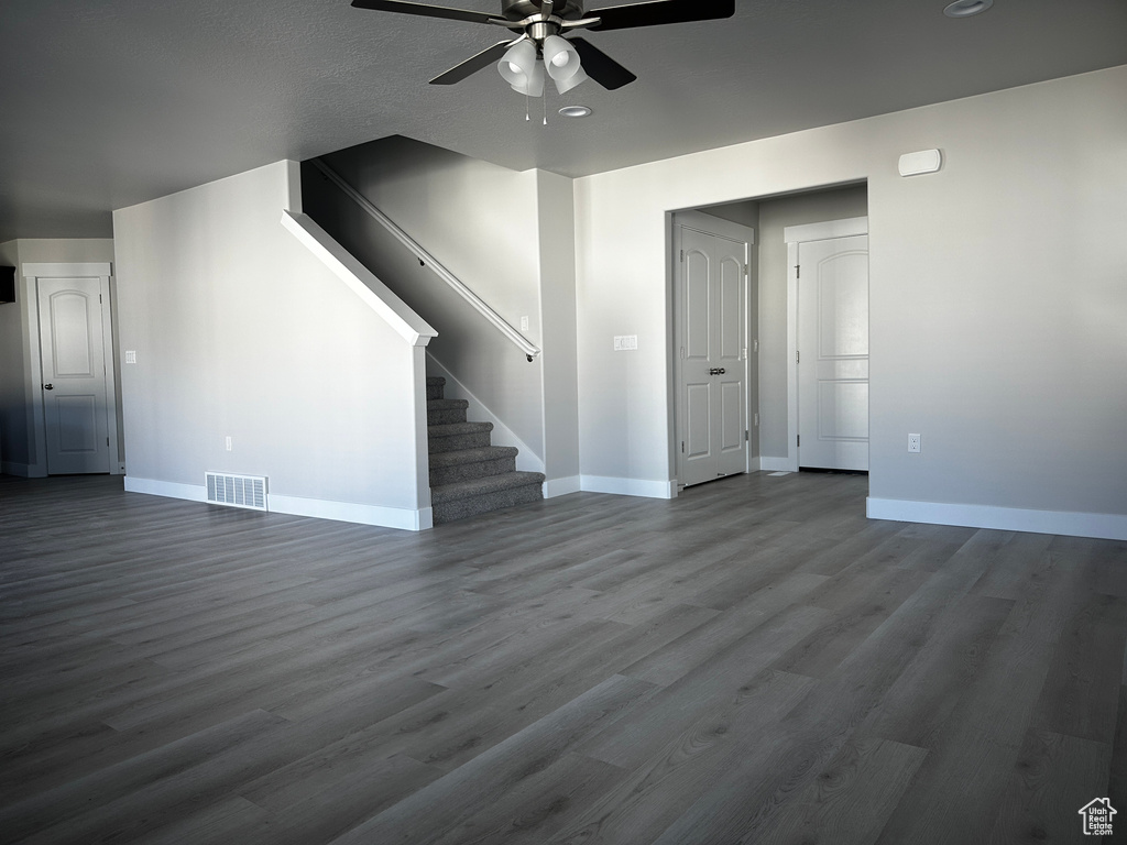 Unfurnished living room with ceiling fan, stairs, dark wood-style flooring, and recessed lighting