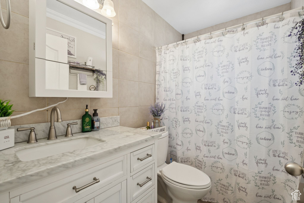 Bathroom with tile walls, vanity, a shower with curtain, and tasteful backsplash