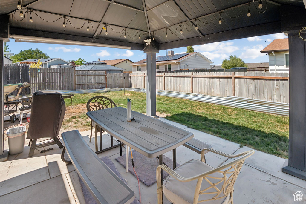 Fenced backyard featuring outdoor dining space, a patio area, and a residential view