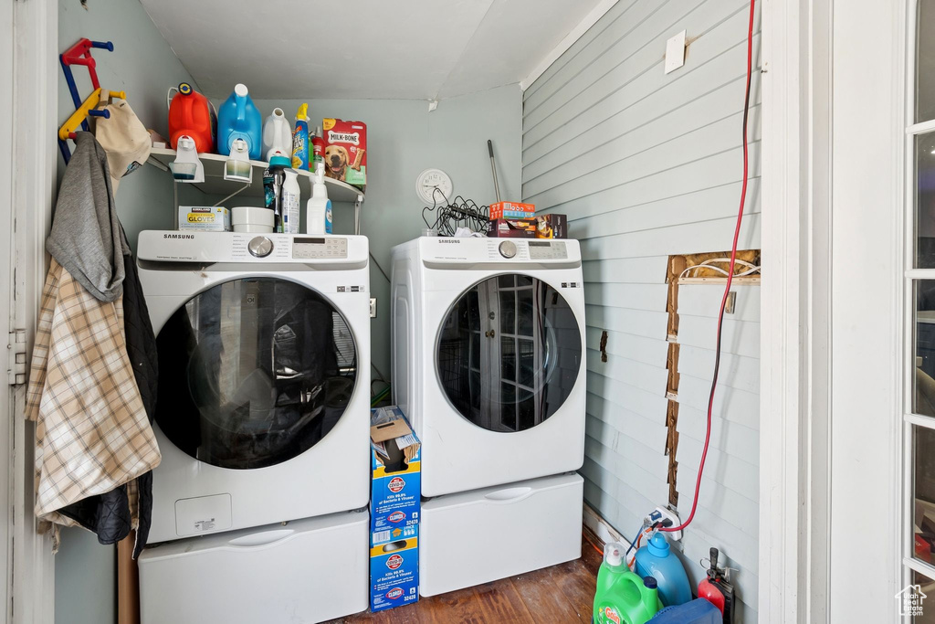 Laundry area featuring washer and clothes dryer, wood finished floors, and wooden walls