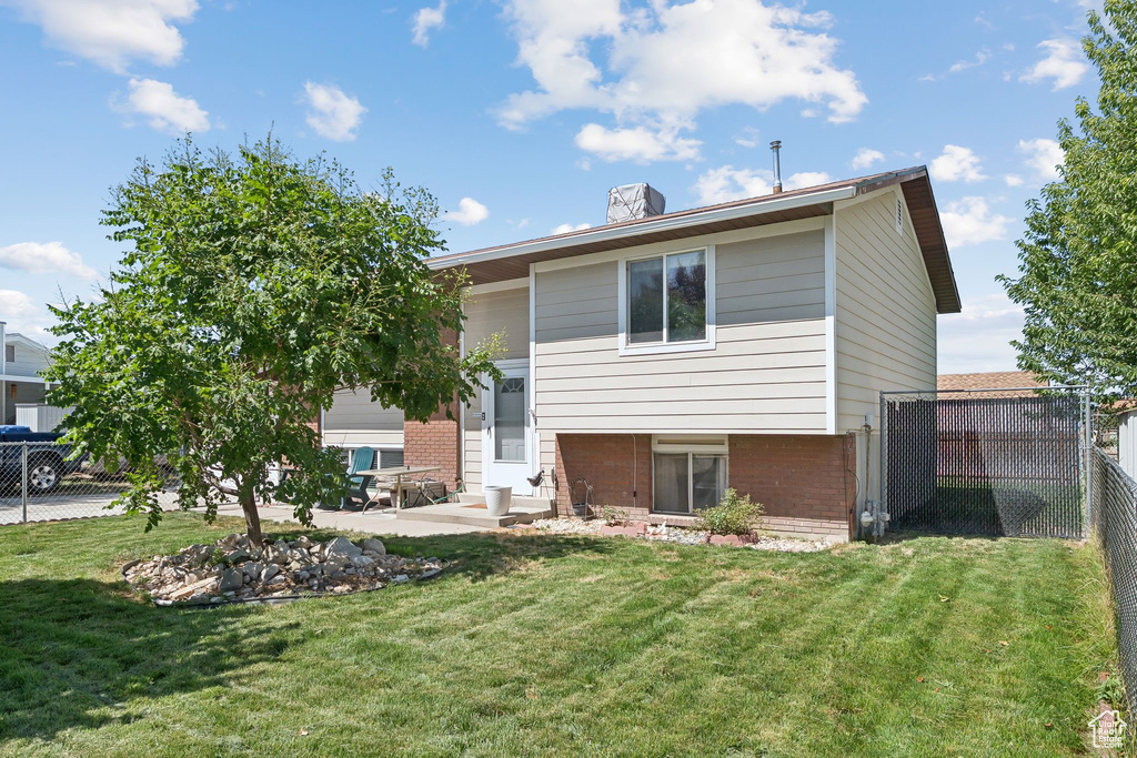 Back of property featuring brick siding, a patio, entry steps, and a chimney