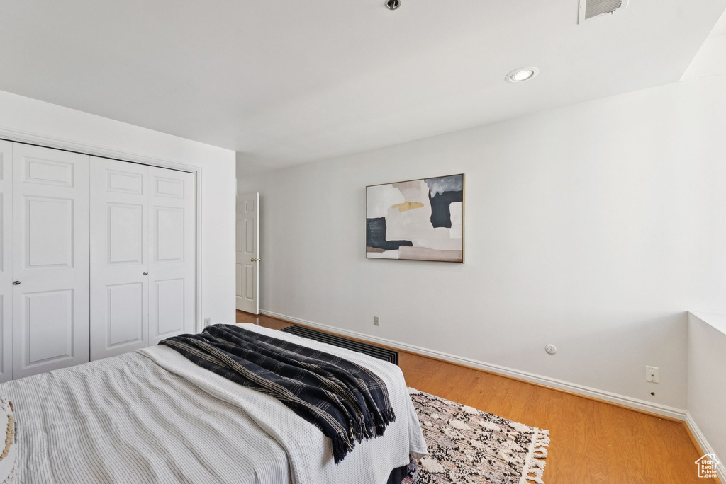 Bedroom with light wood-type flooring, a closet, and recessed lighting